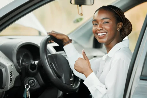 quanto custa manter um carro - Carro novo, retrato de uma mulher negra feliz com o polegar para cima