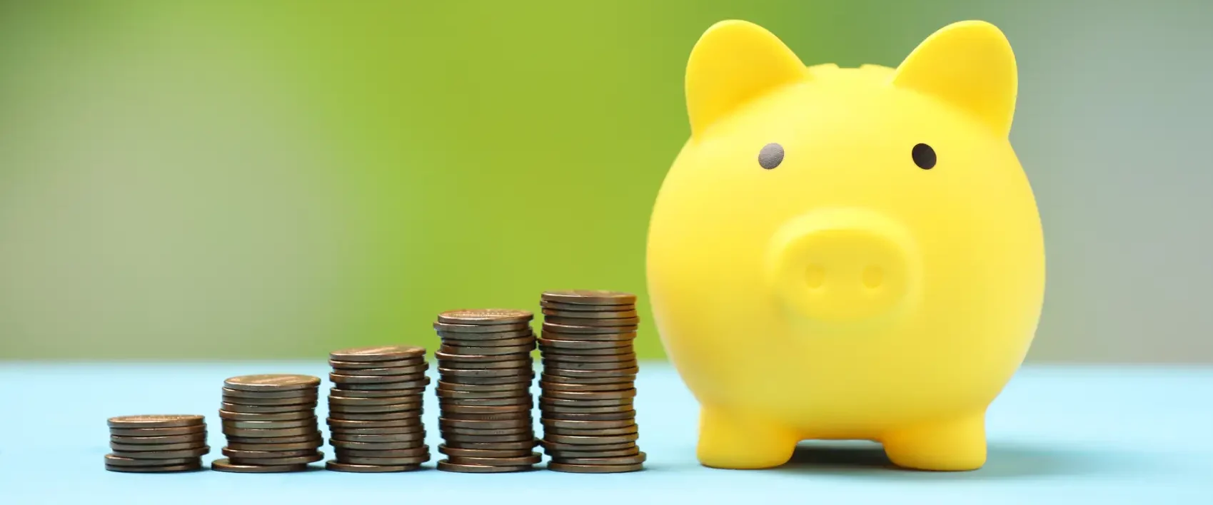 cofrinho pagbank - imagem de cofrinho em forma de porco amarelo com moedas ao lado