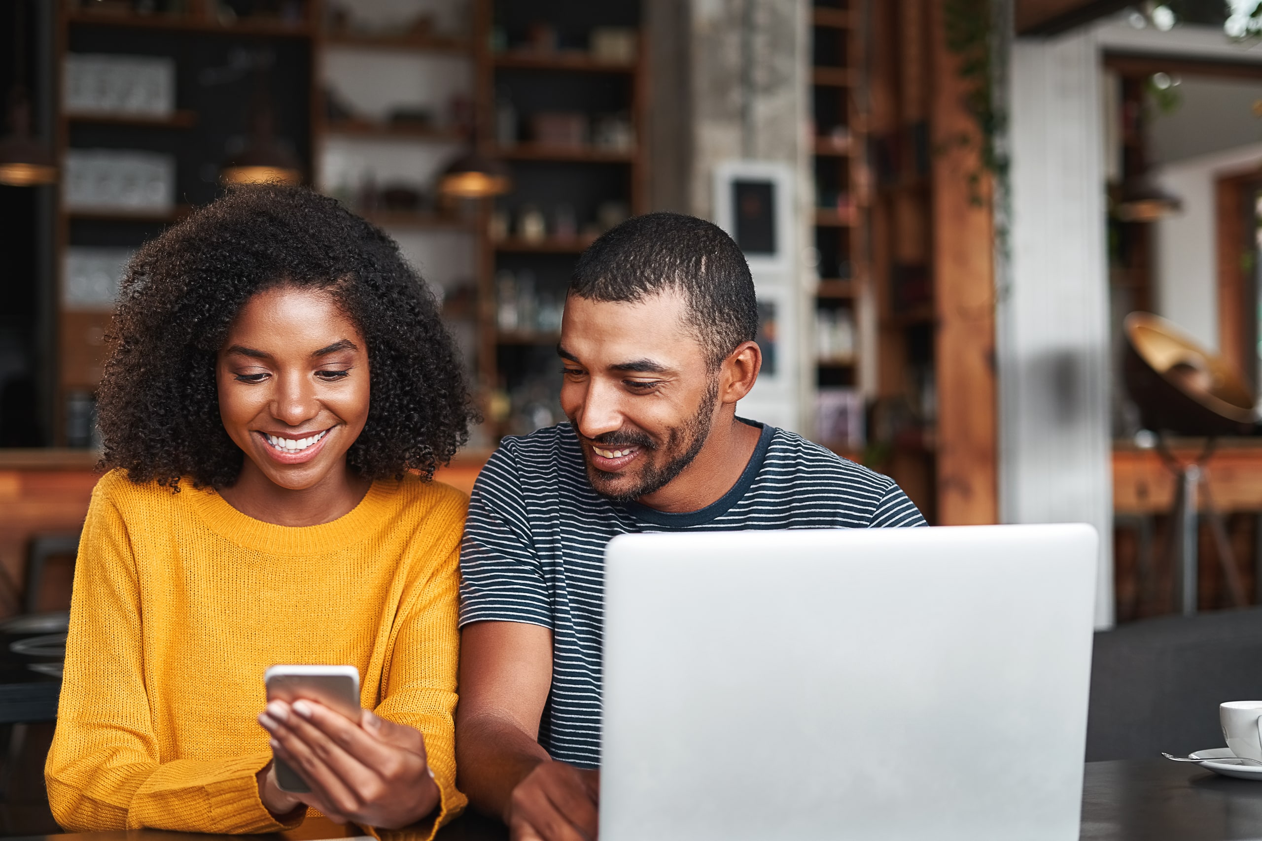 casal com celular e computador avaliando os tipos de crédito