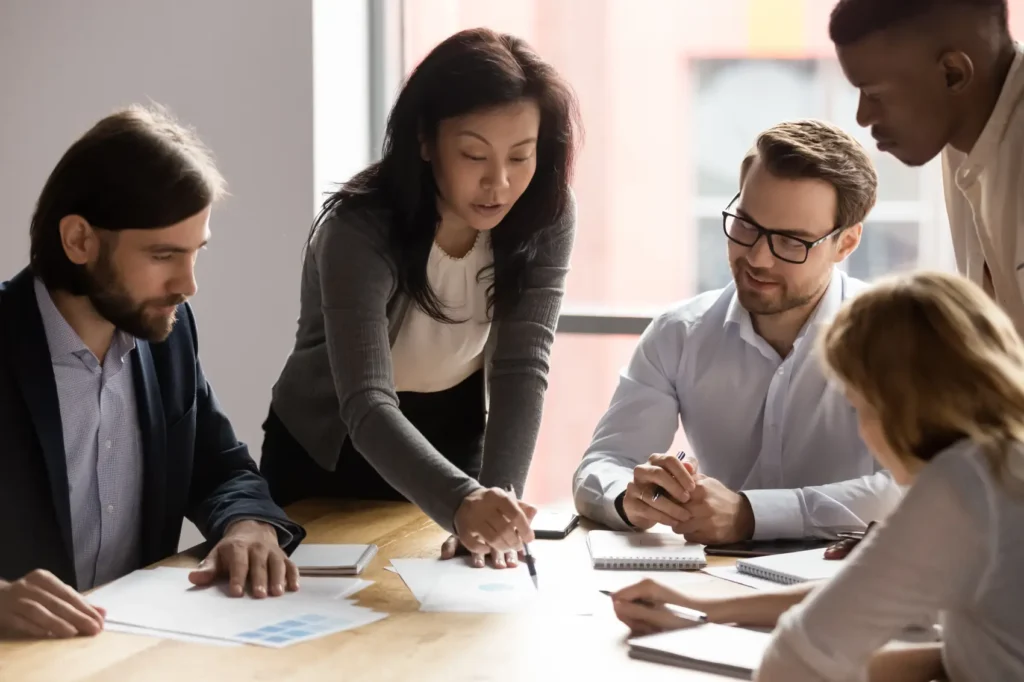 lucro real e lucro presumido - Equipe diversificada de trabalho com uma líder asiática discute dados estatísticos de relatórios