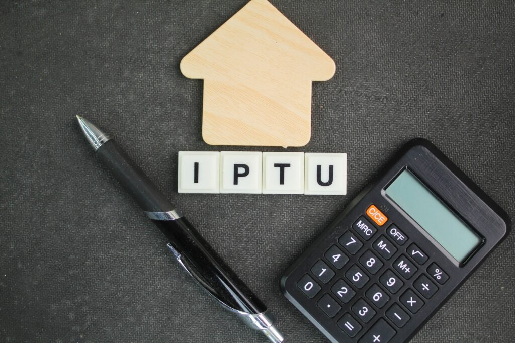 como parcelar o iptu - calculadora, forma de casa e caneta com as letras IPTU