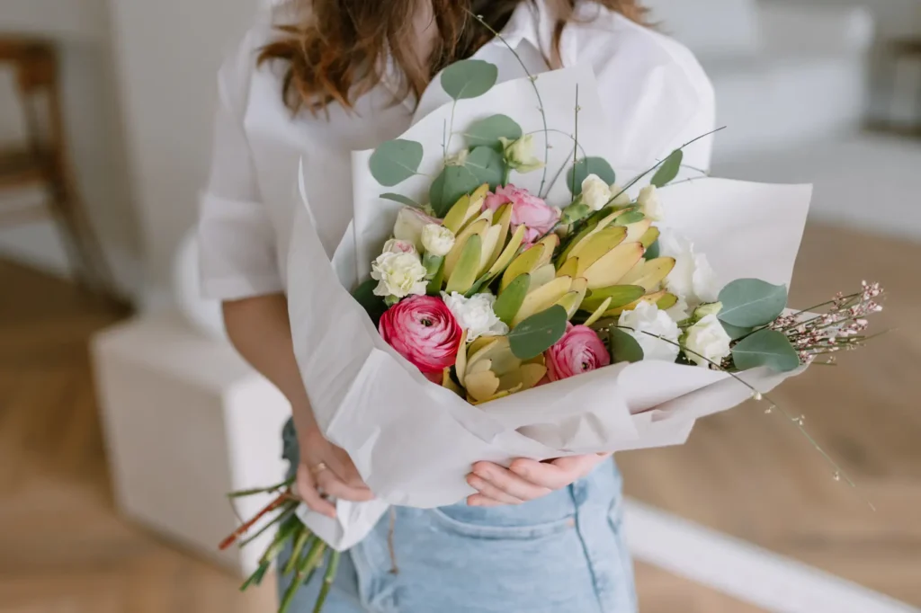 Buquês e flores - Busto feminino segurando buquê de flores coloridas