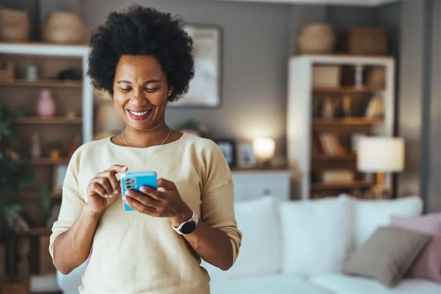 como depositar dinheiro no pagbank - mulher negra segurando o celular e sorrindo