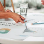 estrategia-de-marketing mesa com copo de água e papéis voltados para o marketing