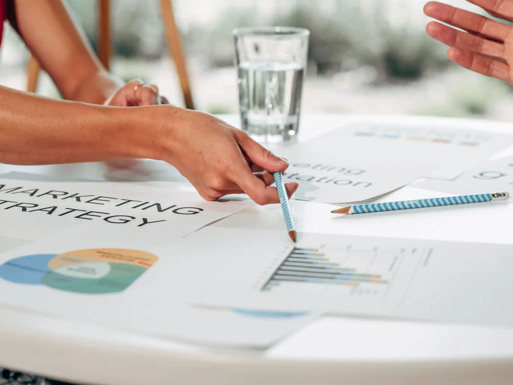 estrategia-de-marketing mesa com copo de água e papéis voltados para o marketing