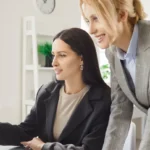 faturamento e lucro - sérias empresárias verificam dados, contam lucros, pagam contas, administram finanças próprias da empresa na mesa usando o computador