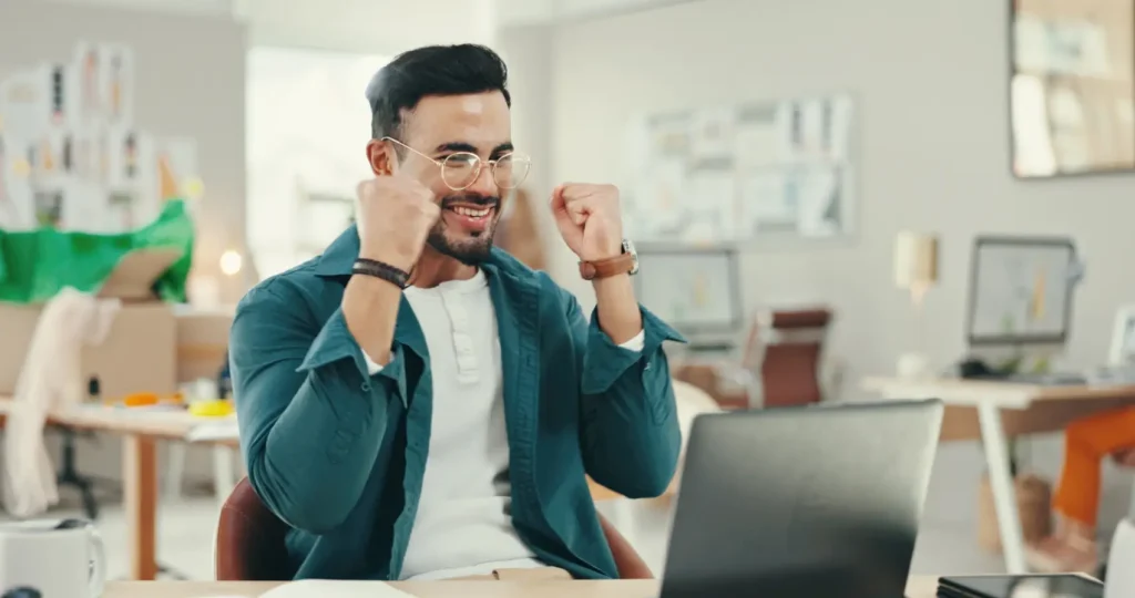 como amortizar empréstimo consignado - homem branco feliz em frente ao notebook