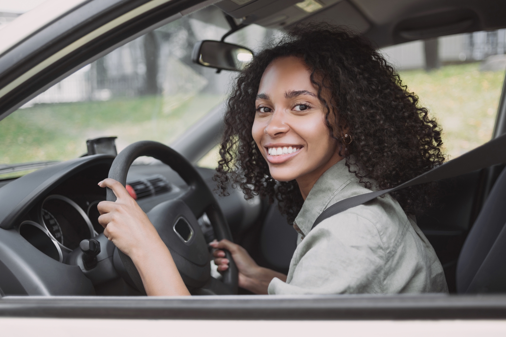 ipva a vista ou parcelado - Ao volante. Jovem sorridente dirigindo um carro.