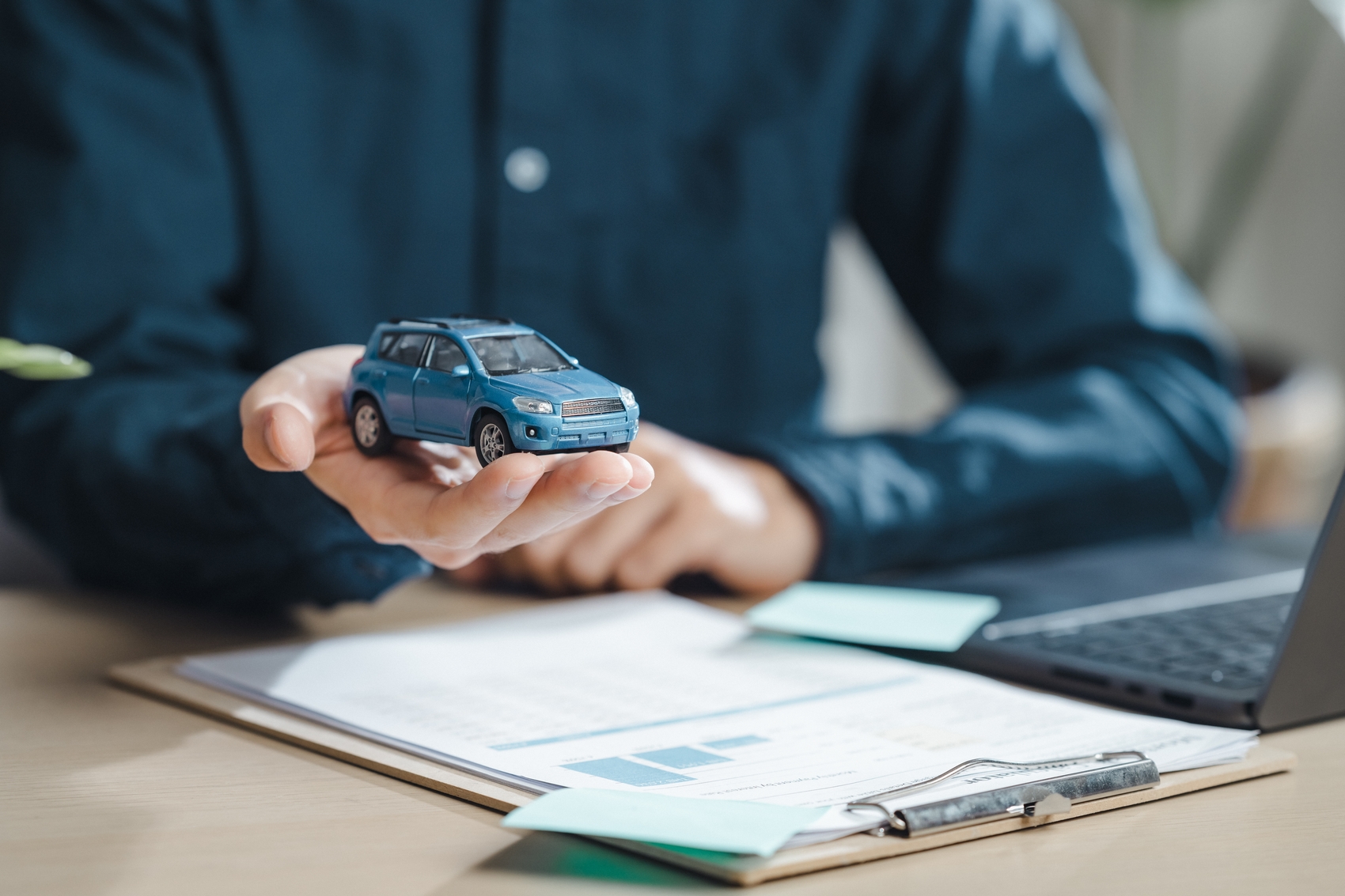 como pagar ipva - Um homem está segurando um carro de brinquedo em sua mão