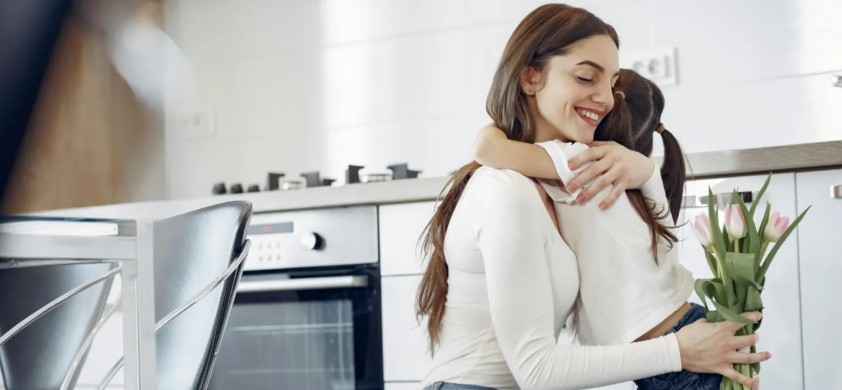 o que vender no dia das mães -mãe abraçando filha com buquê de flor