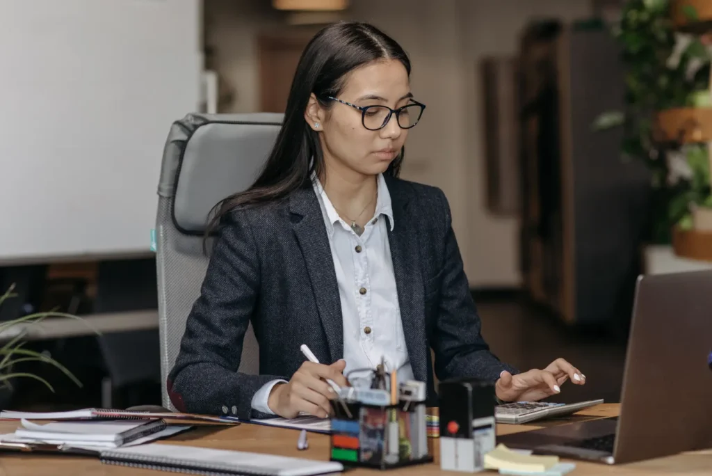tabela-do-imposto-de-renda mulher com notebook fazendo cálculos com calculadora