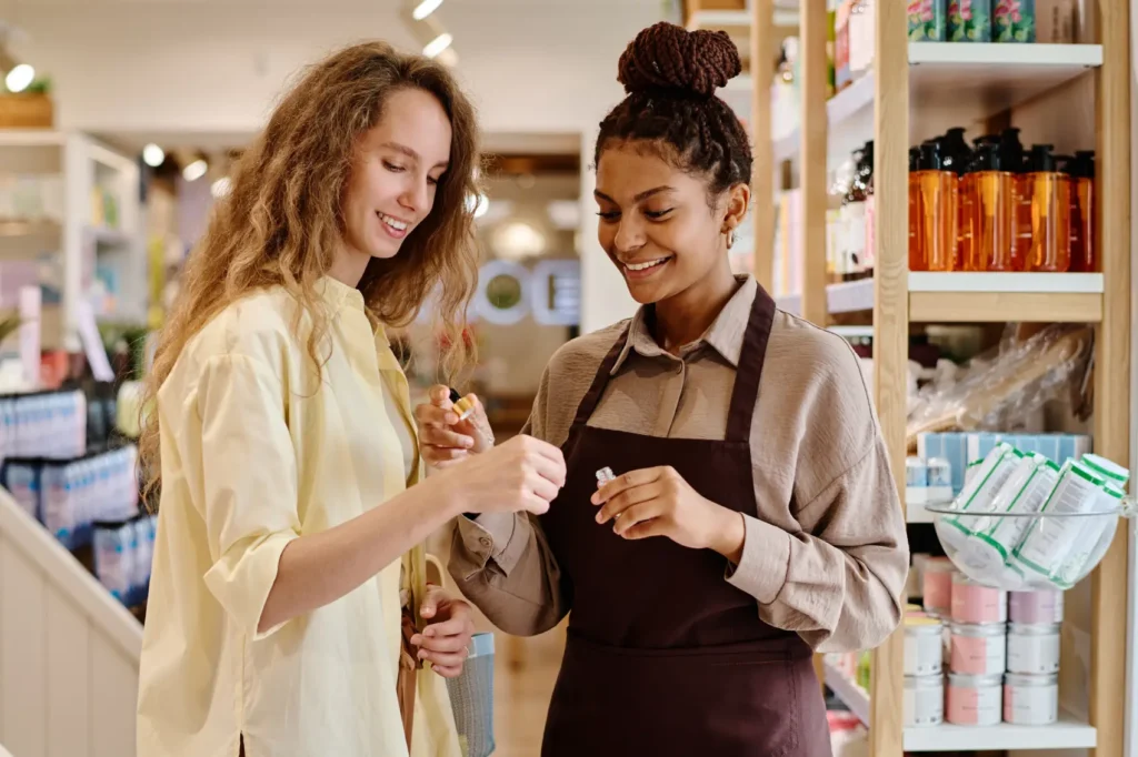 gestão de relacionamento com o cliente - funcionária mostra perfume para cliente em loja de perfumes