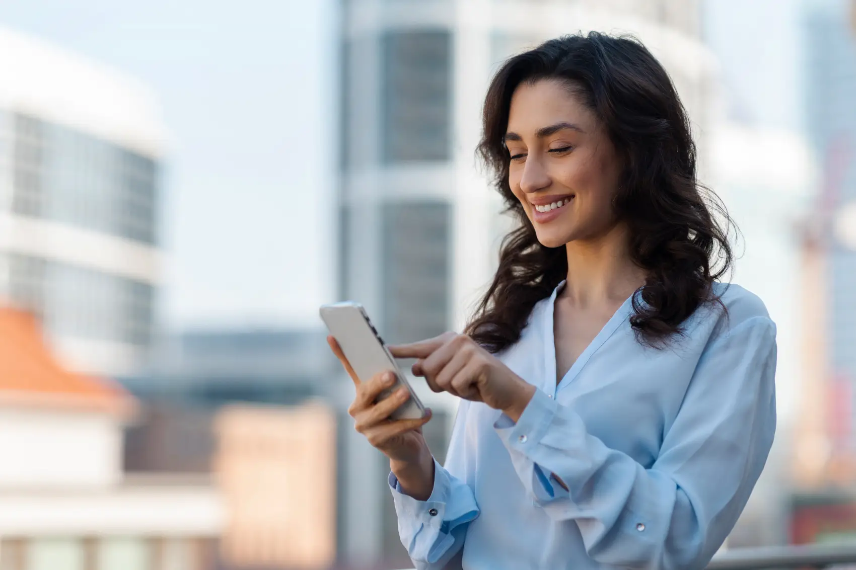 link de pagamento pagbank - Jovem empresária alegre em roupa formal usando telefone celular e sorrindo ao ar livre