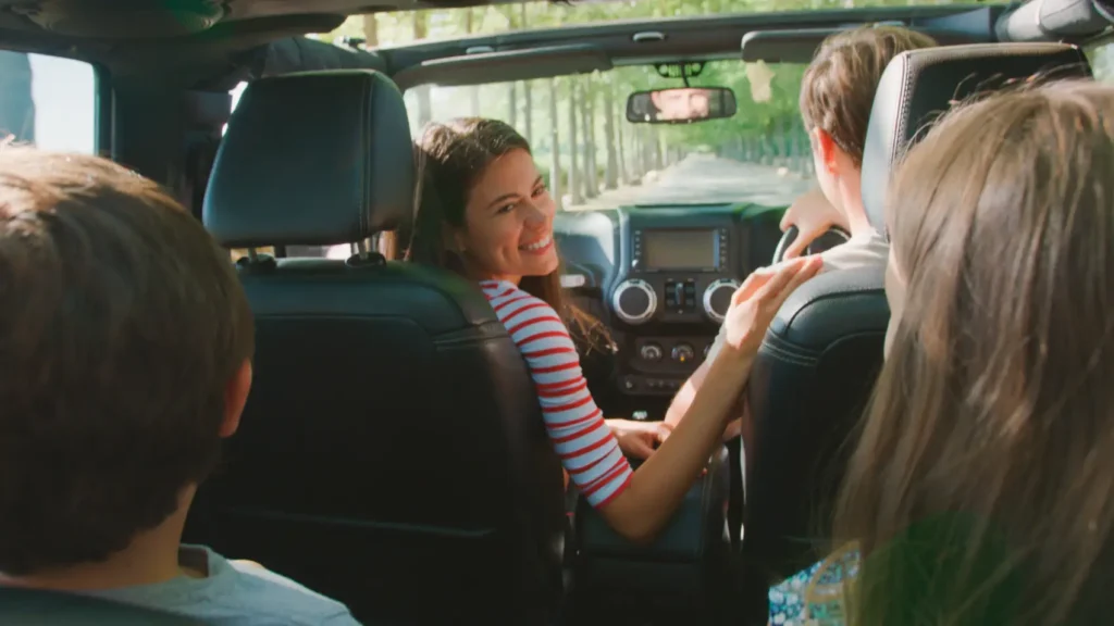 calcular custo de viagem - família feliz dentro de um carro pela visão do banco de trás