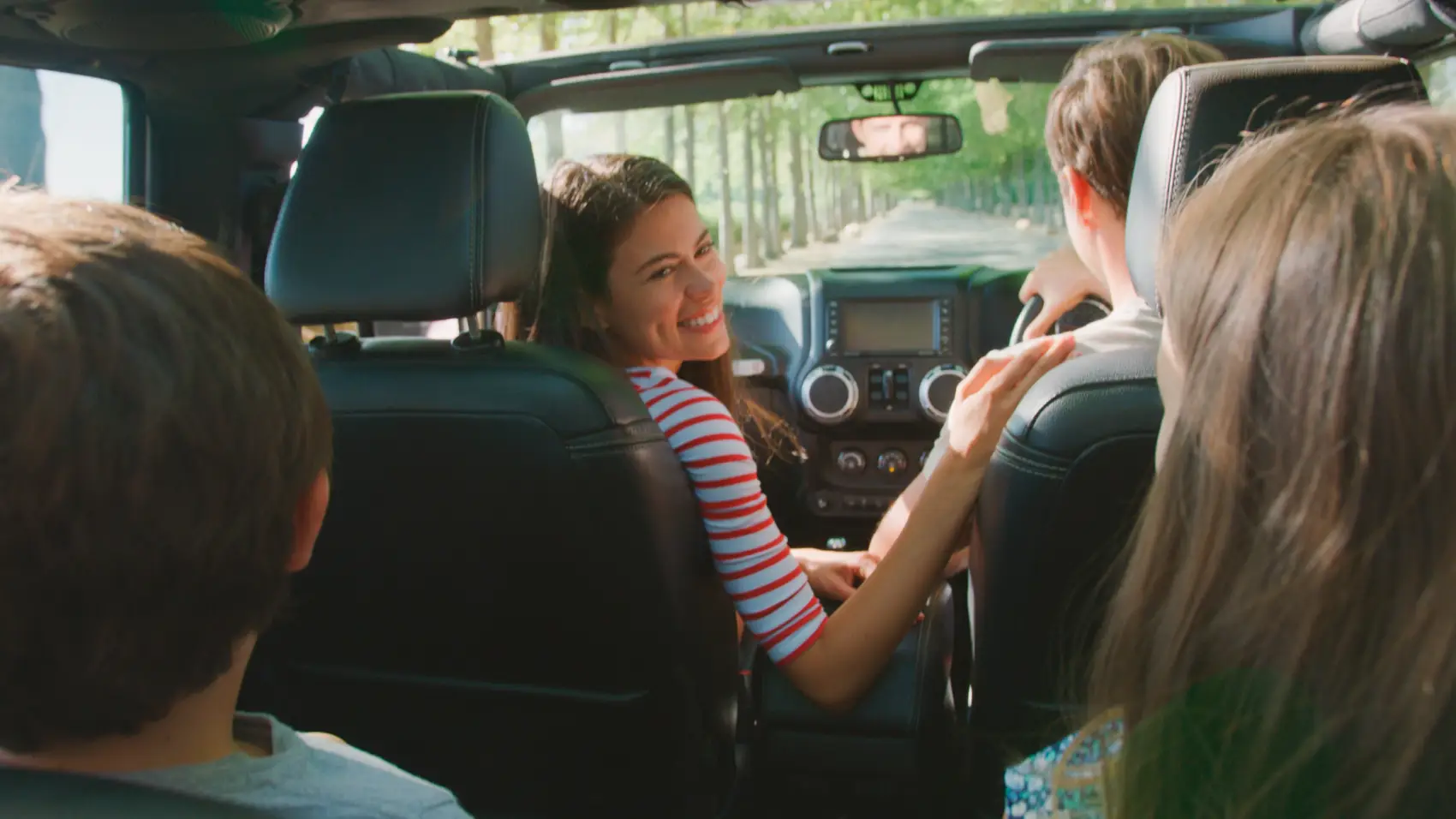 calcular custo de viagem - família feliz dentro de um carro pela visão do banco de trás