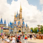 quanto custa uma viagem para disney - castelo da disney orlando visto de longe, com diversas pessoas andando nos arredores