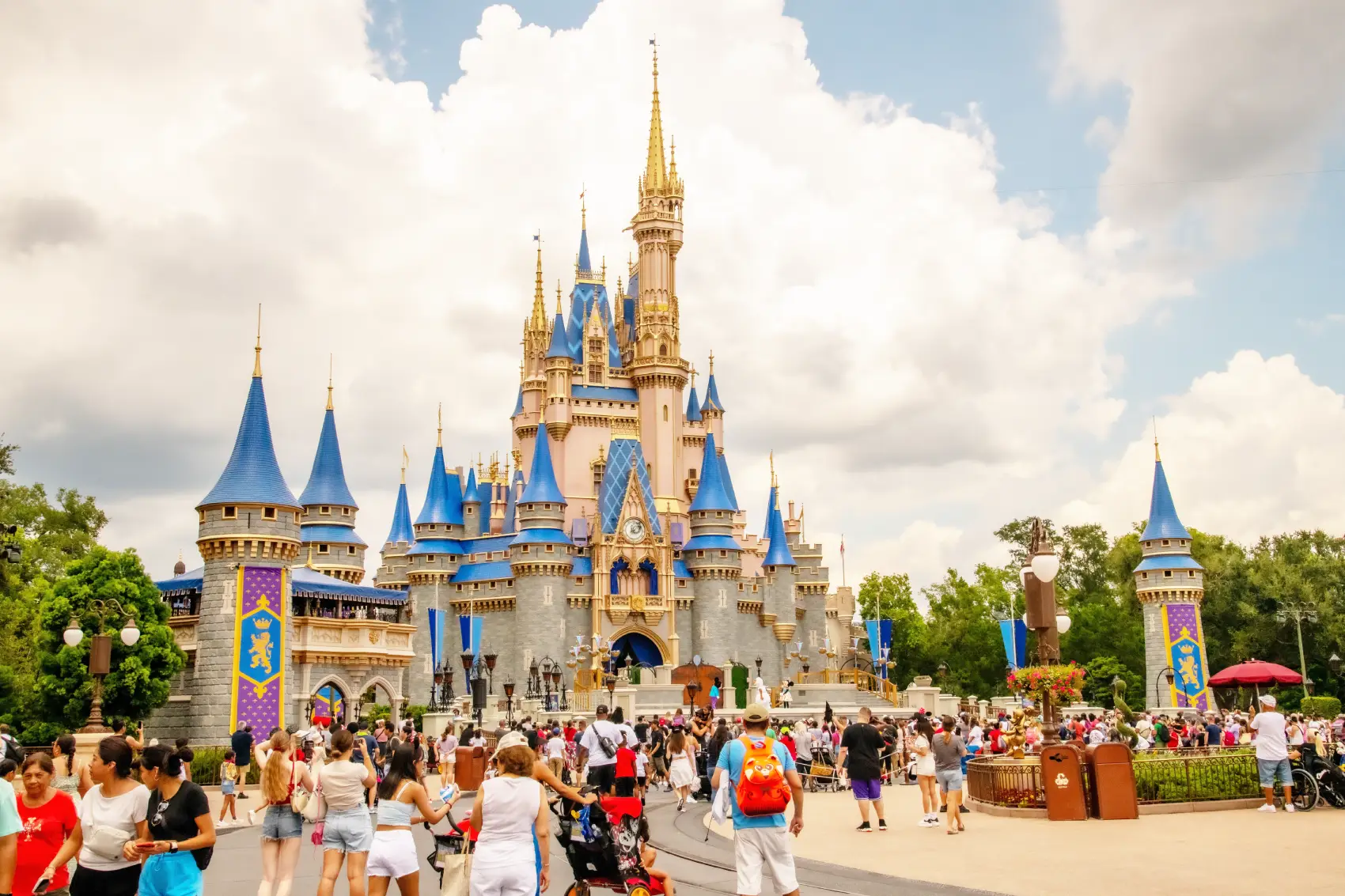 quanto custa uma viagem para disney - castelo da disney orlando visto de longe, com diversas pessoas andando nos arredores