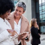 o que fazer com a restituição do imposto de renda - Mulheres de negócios maduras e multirraciais conversando alegremente