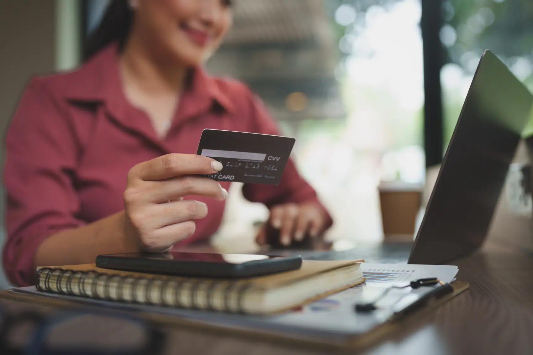 como funciona o juros do cartão de credito - Mulher de negócios mulher asiática usando laptop e cartão de crédito no trabalho