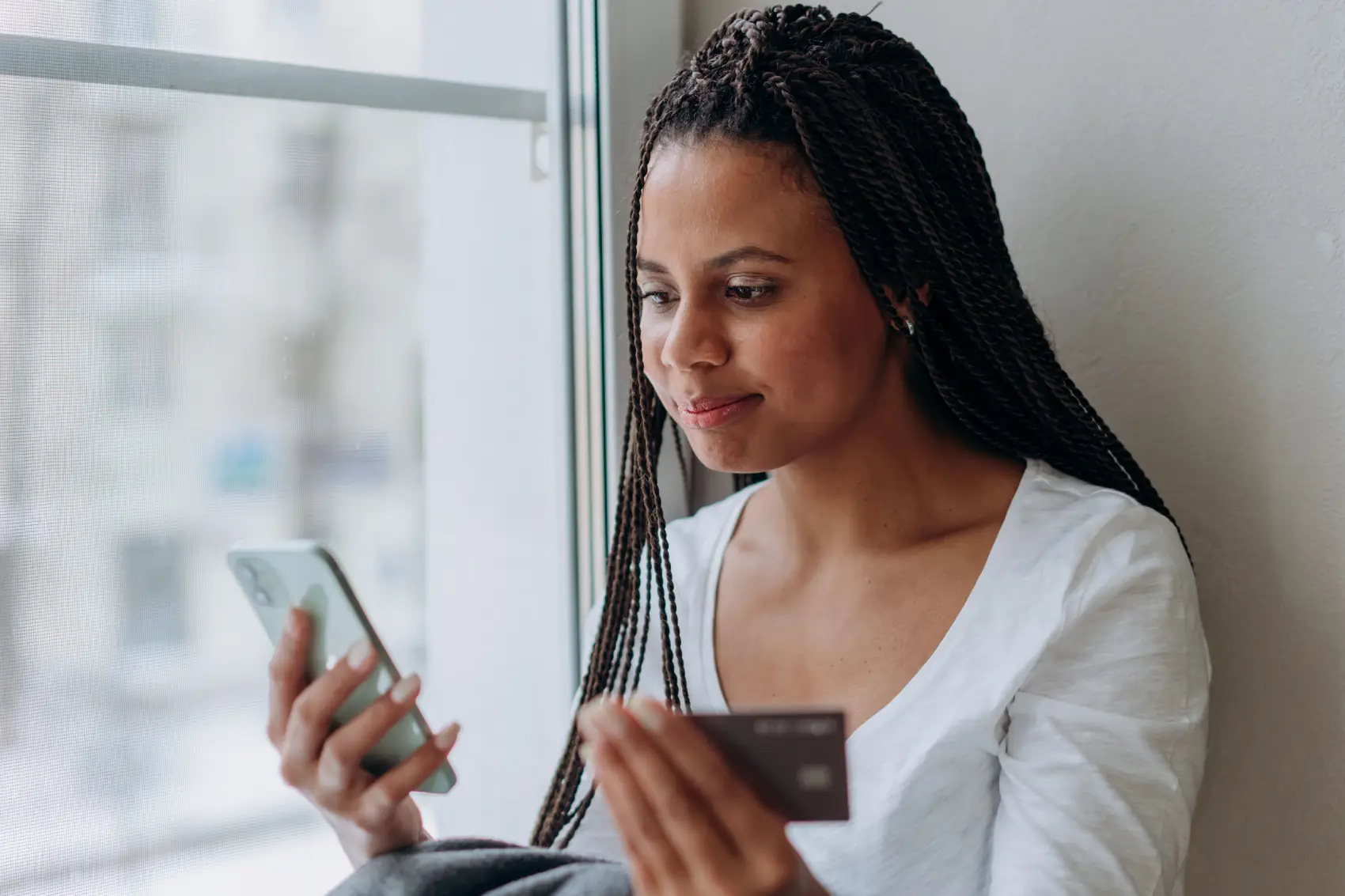 pix-no-credito mulher com celular e cartão de crédito nas mãos