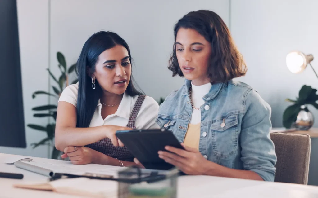 como abrir empresa de prestação de serviços​ - colegas de trabalho conversando olhando um tablet