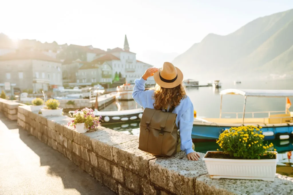 como planejar uma viagem internacional - Turista mullher admirando a vista colorida da cidade