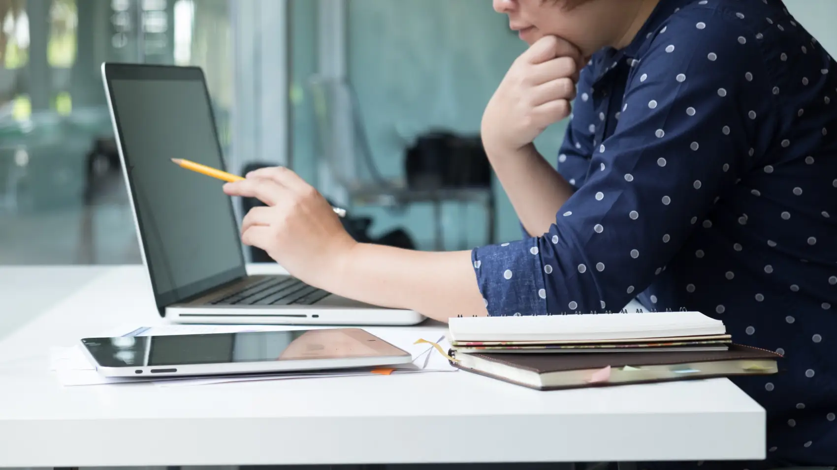custo de aquisição de clientes - vendedor/empresário usando um laptop para calcular gráficos e estatísticas de crescimento em uma mesa de escritório