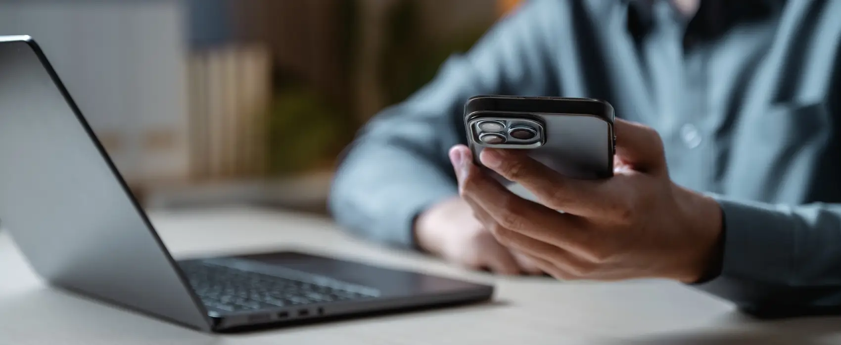 malware sorvepotel - mão segurando um celular com metade do notebook amostra