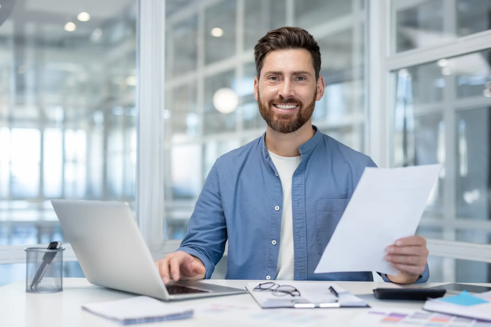 cnpj para microempreendedor - empresário sorridente trabalhando na mesa de seu escritório