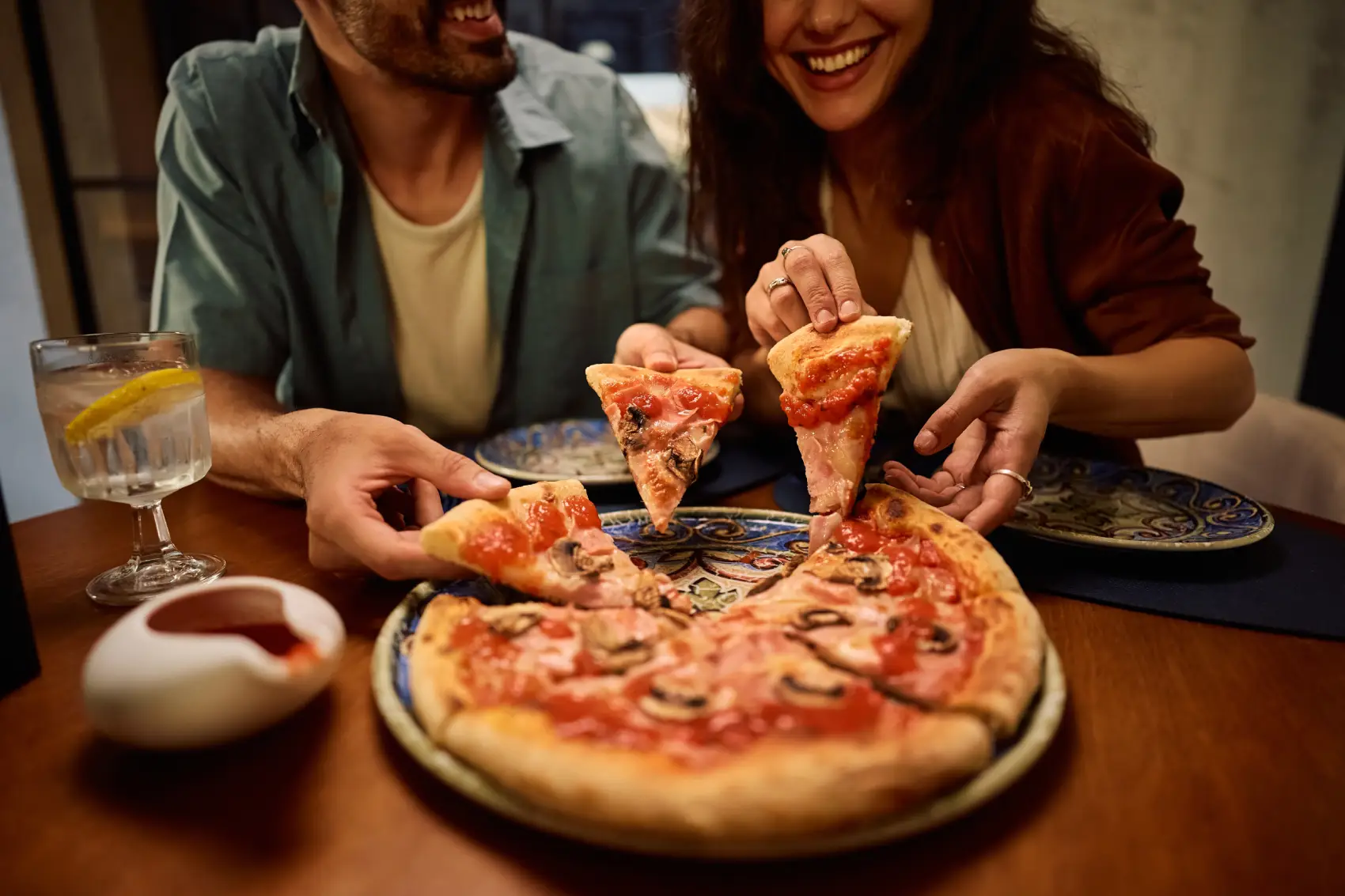 dia da pizza - Close do casal comendo pizza na pizzaria