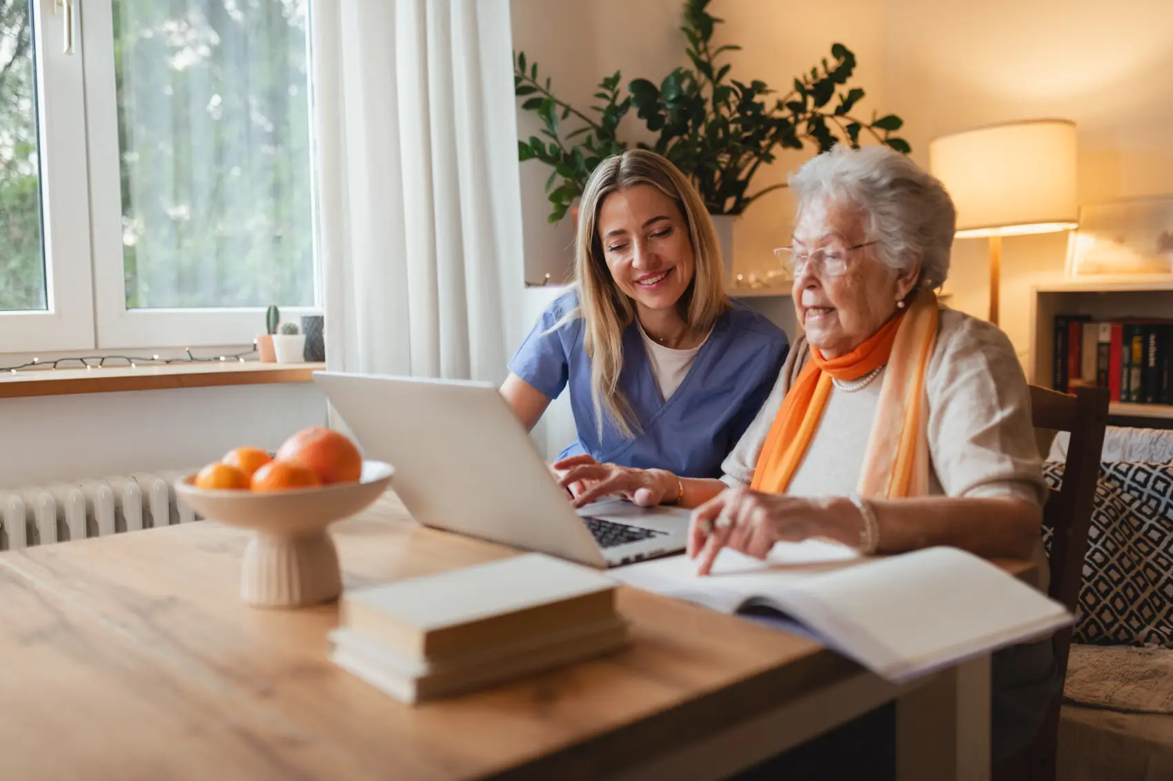 educação financeira para idosos - neta ajudando a avó com o gerenciamento de suas finanças, ensinando-a a usar o banco on-line no laptop.